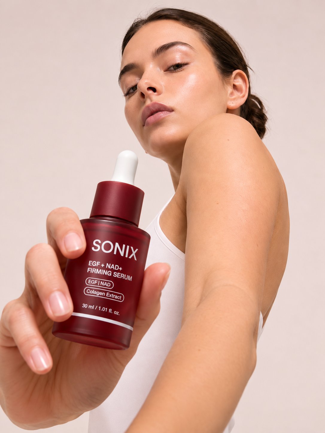 Model presenting the SONIX serum bottle